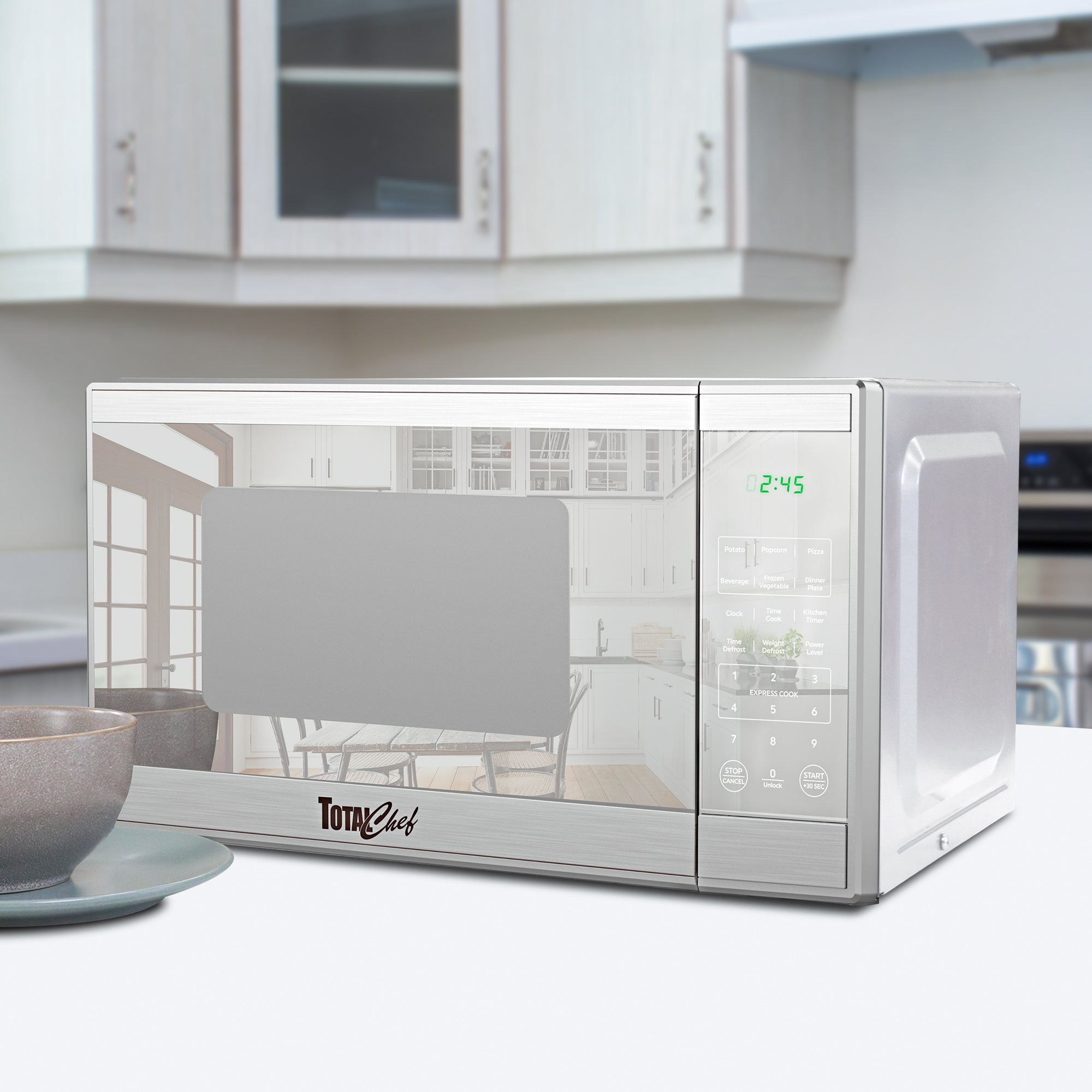 Total Chef stainless steel microwave, closed, in a modern white kitchen