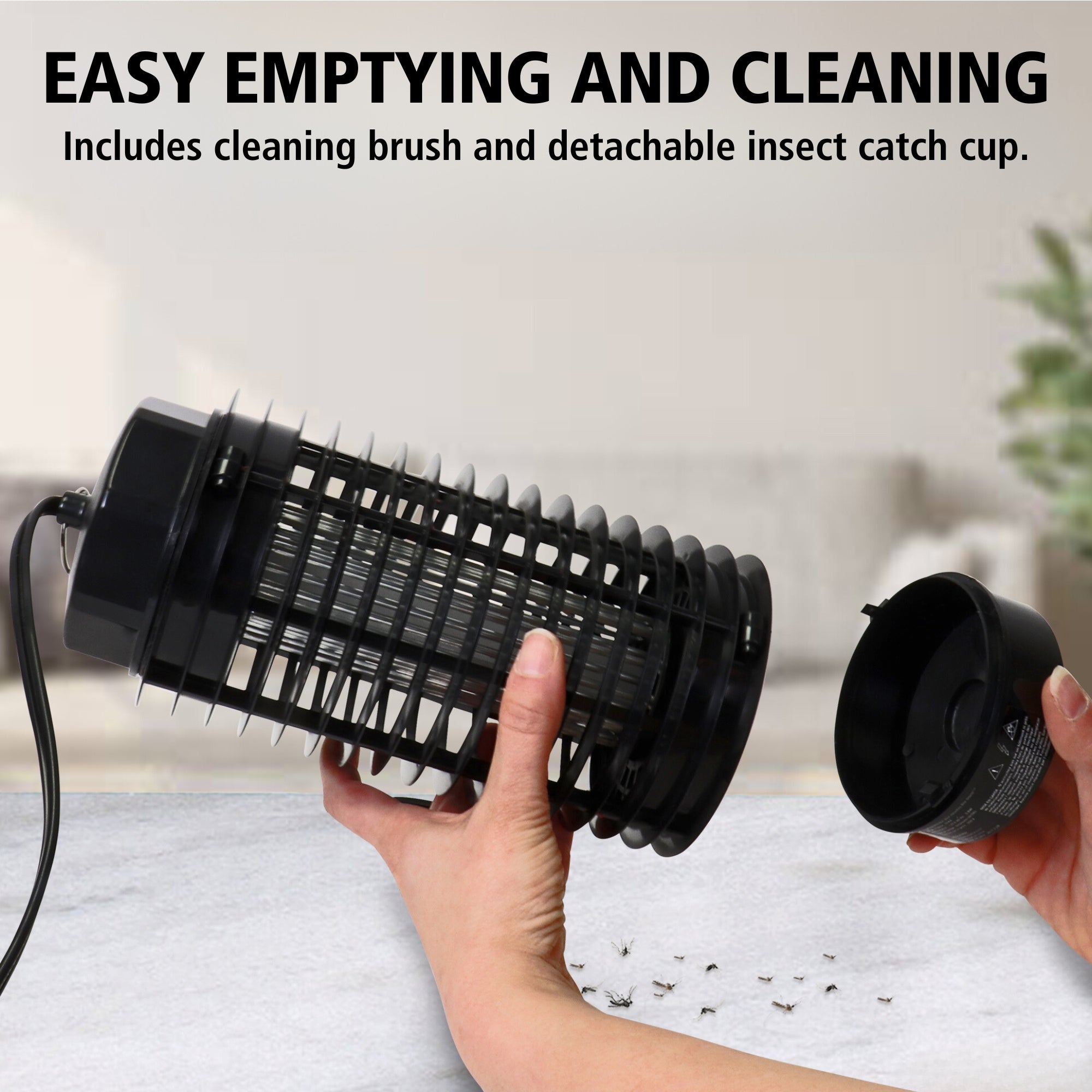 Two hands holding the Bite Shield electronic flying insect zapper and detachable insect catch cup with dead mosquitoes on a white and gray counter below. Text above reads, "Easy emptying and cleaning: Includes cleaning brush and detachable insect catch cup"