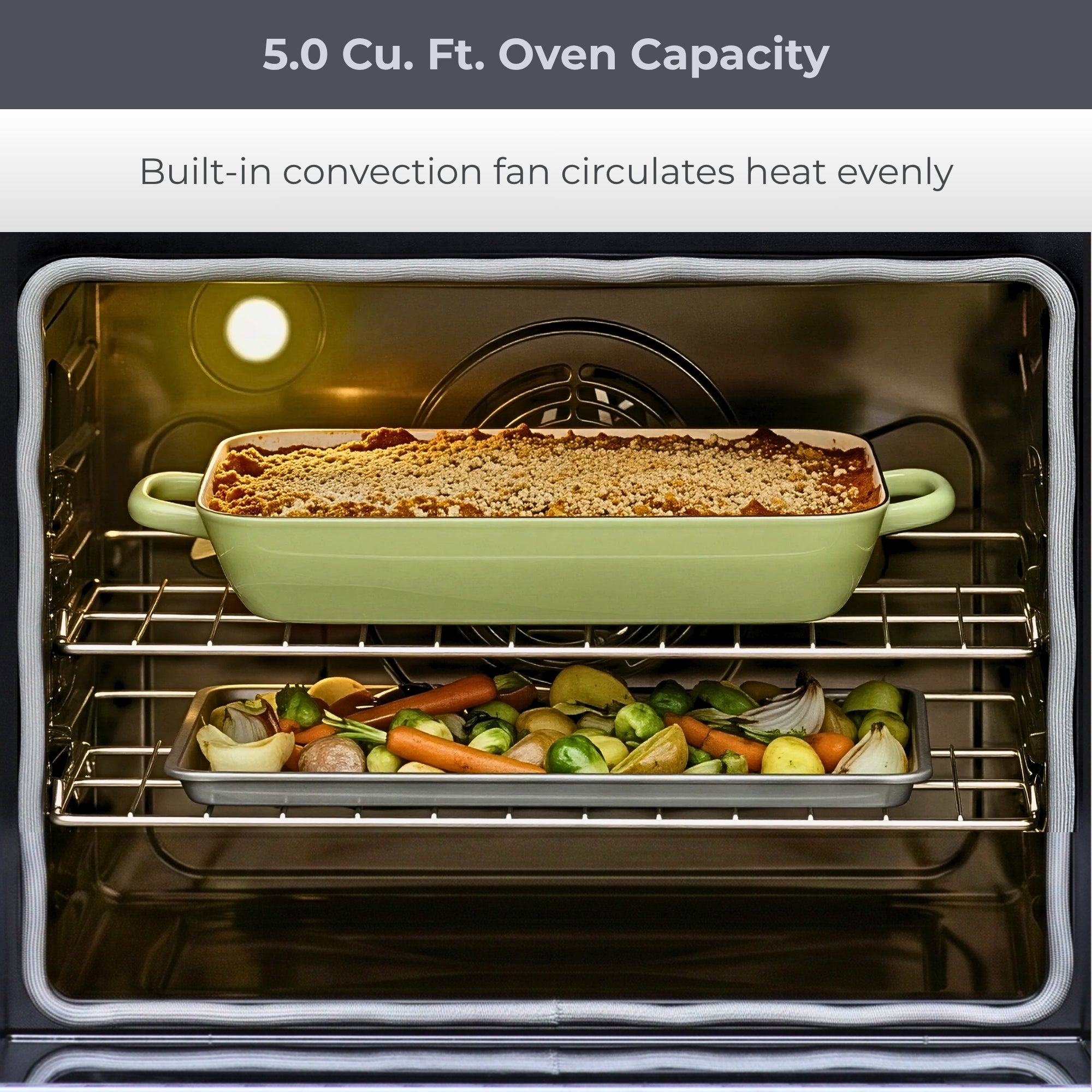 Closeup of the open Kenmore coil top electric range showing food cooking on two racks. Text above reads, "5.0 Cu. Ft. Oven Capacity: Built-in convection fan circulates heat evenly"