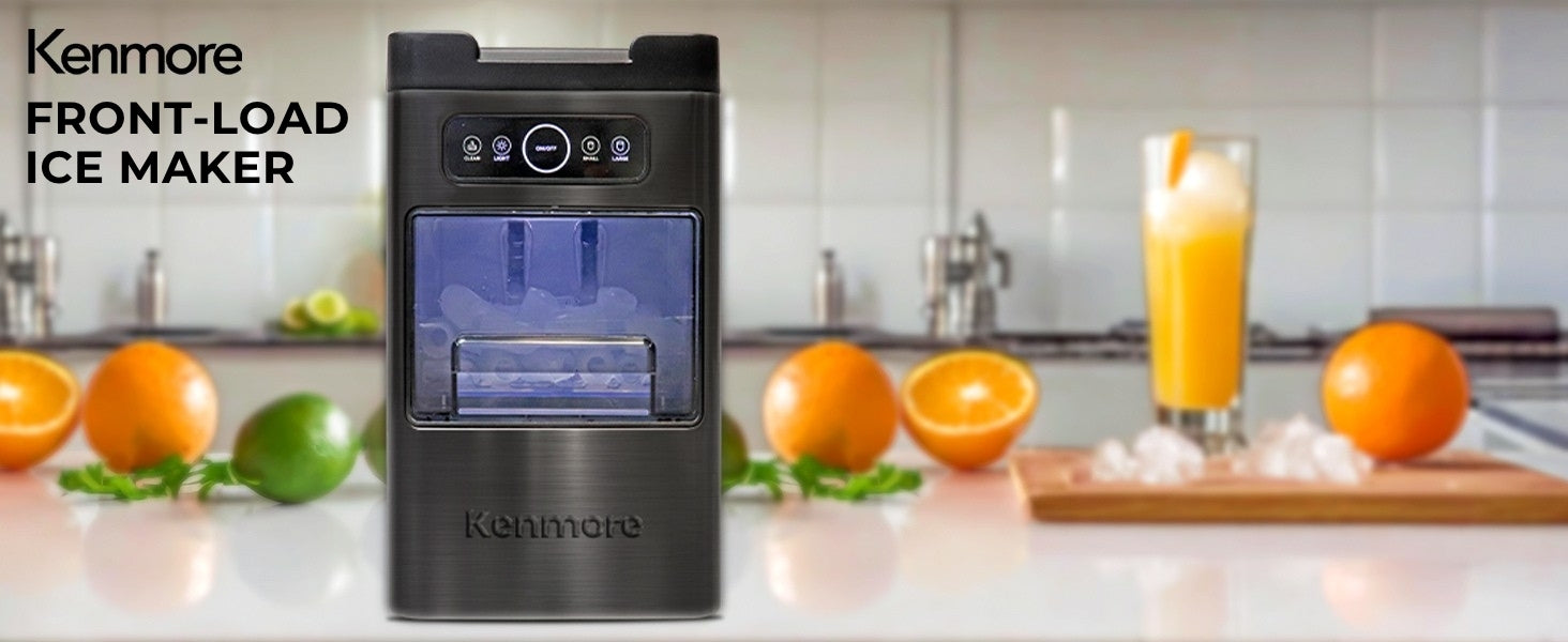 Kenmore front-load ice maker on a white counter surrounded by oranges and fresh orange juice