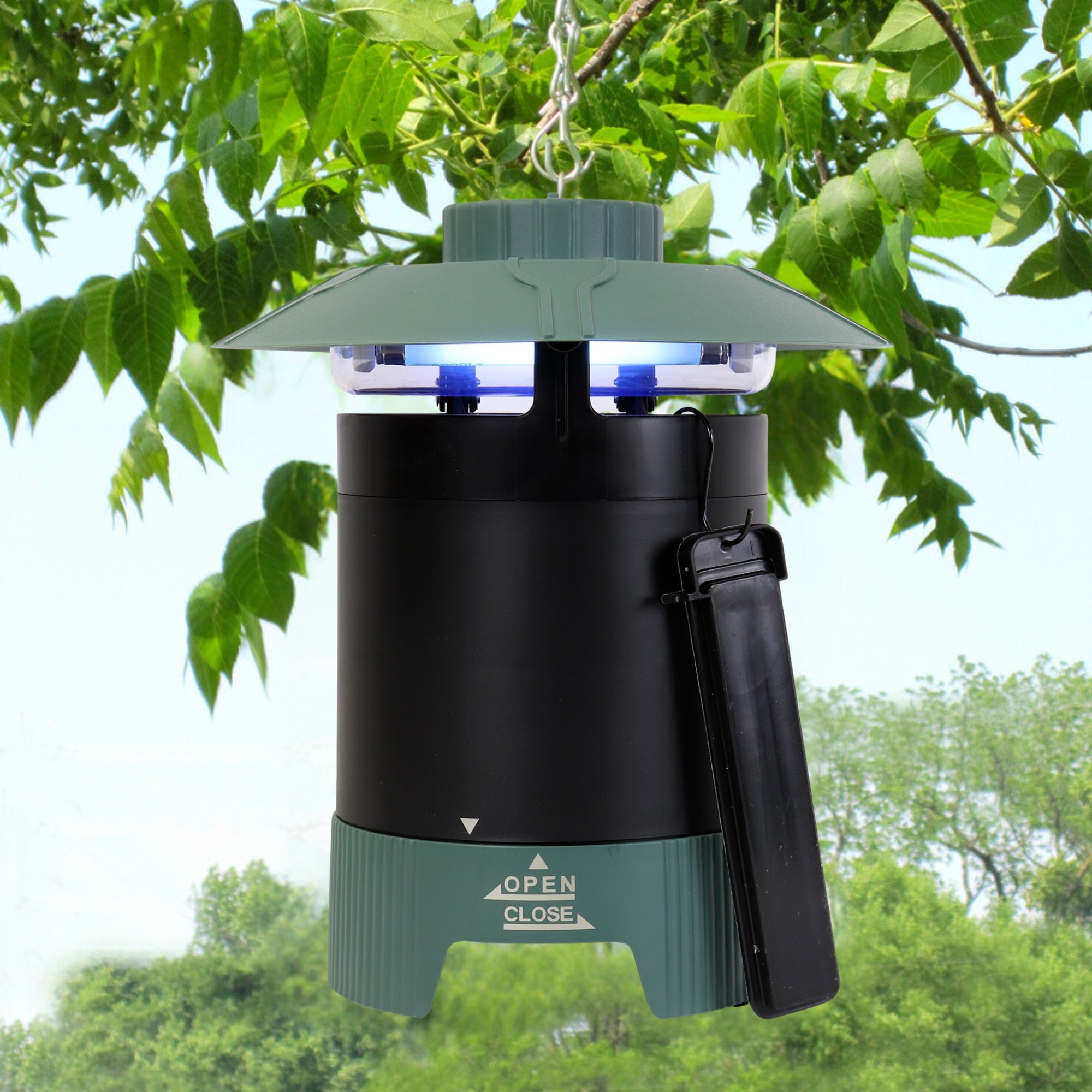 Bite Shield Protector 1/4 acre mosquito trap with Octenol lure attached hanging from a tree branch with a wooded area in the background.