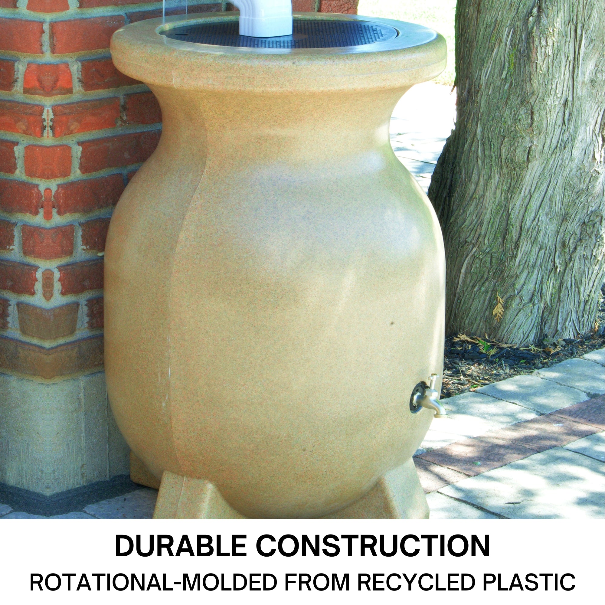 Closeup of the top half of a Koolscapes decorative sandstone-look rainwater urn set up below a white downspout with a red brick wall in the background. Text below reads, "55 gallon (210L) capacity: Fully open top for maximum water capture."